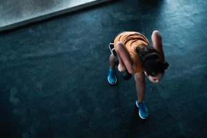 woman in orange top exercising indoors